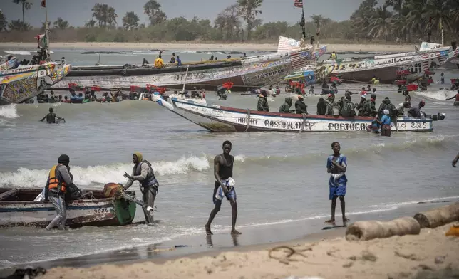 Artisanal fishermen sell their catch from boats to local fishmongers at the coastal community of Gunjur, Gambia, on March 23, 2025. (AP Photo/Grace Ekpu)