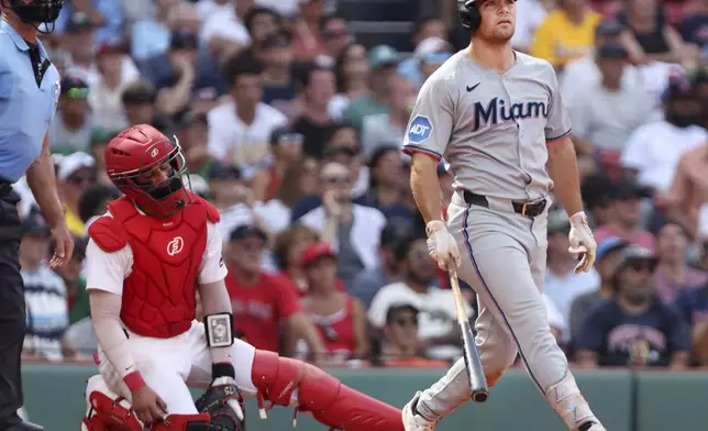 The Miami Marlins' Jakob Marsee, right, watches the flight of his two-run home run in the ninth inning, while Boston Red Sox's catcher Carlos Narvaez reacts at left during a baseball game, Sunday Aug.17, 2025 in Boston. (AP Photo/Jim Davis)