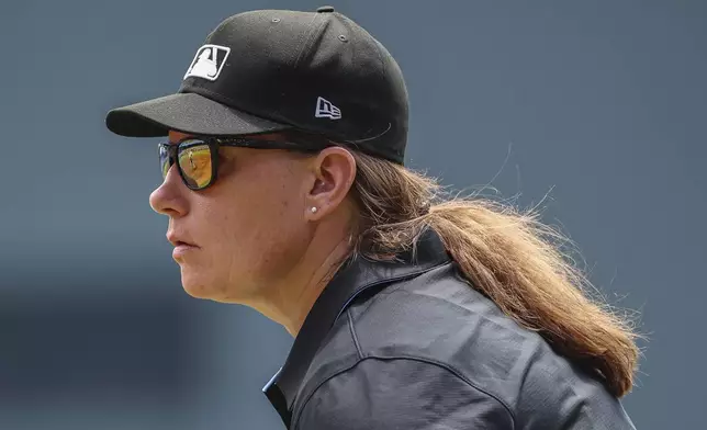 Umpire Jen Pawol, looks on during the first inning of a baseball game of a doubleheader between the Atlanta Braves and Miami Marlins, Saturday, Aug. 9, 2025, in Atlanta. (AP Photo/Colin Hubbard)