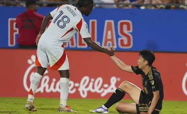 Los Angeles FC forward Heung Min Son, right, gets a hand up from FC Dallas defender Shaq Moore (18) during the second half of an MLS soccer match in Frisco, Texas, Saturday, Aug. 23, 2025. (AP Photo/LM Otero)