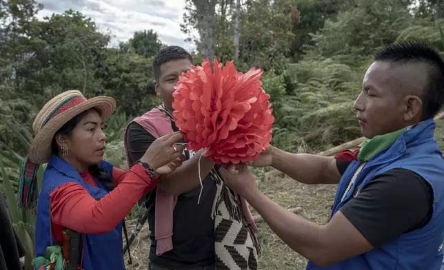 Indigenous Guards, including Patricia Elago Zetty, left, prepare decorations for a graduation ceremony on July 18, 2025, in Manuelico village, Caldono, Colombia. (AP Photo/Nadège Mazars)