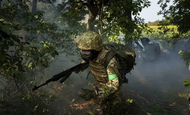 A Ukrainian National Guard serviceman of 3rd brigade «Spartan» runs through a tree line during a training not far from the frontline on Pokrovsk direction, Ukraine, on Friday, August 8, 2025. (AP Photo/Evgeniy Maloletka)