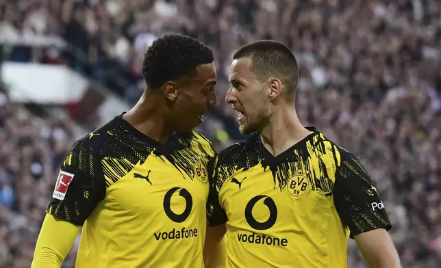 Dortmund's Waldemar Anton, right, celebrates with teammate Felix Nmecha after scoring during the German Bundesliga soccer match between FC St. Pauli and Borussia Dortmund at Millerntor Stadium in Hamburg, Germany, Saturday, Aug. 23, 2025. (Sina Schuldt/dpa via AP)