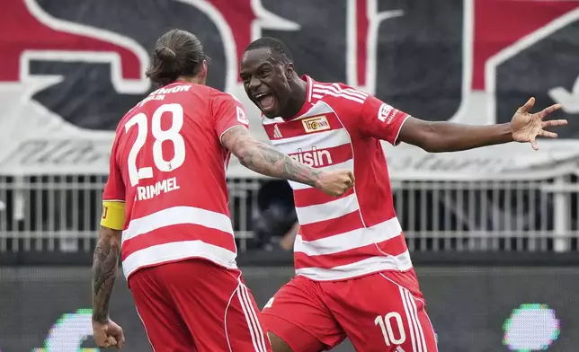 Union's Ilyas Ansah, right, celebrates with Union's Christopher Trimmel after scoring the opening goal during the German Bundesliga soccer match between FC Union Berlin and VfB Stuttgart, at the An der Alten Forsterei stadium in Berlin, Germany, Saturday, Aug. 23, 2025. (AP Photo/Ebrahim Noroozi)