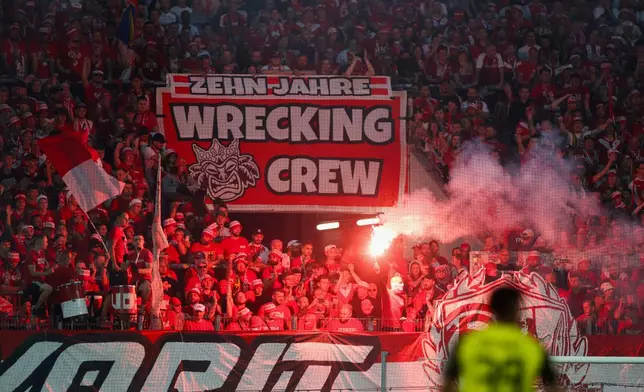 Essen fans set off Bengal fires in the fan block during a German Cup first-round soccer match between Essen and Borussia Dortmund, at Stadion an der Hafenstrasse in Essen, Germany, Monday, Aug. 18, 2025. (Christoph Reichwein/dpa via AP)
