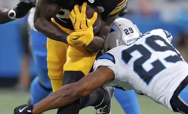 Pittsburgh Steelers running back Kaleb Johnson is tackled by Carolina Panthers cornerback Akayleb Evans during the first half of an NFL preseason football game, Thursday, Aug. 21, 2025, in Charlotte, N.C. (AP Photo/Rusty Jones)