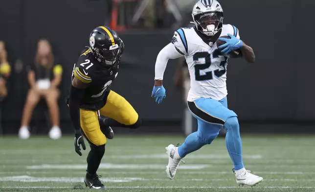 Carolina Panthers running back Trevor Etienne runs past Pittsburgh Steelers safety Chuck Clark during the first half of an NFL preseason football game, Thursday, Aug. 21, 2025, in Charlotte, N.C. (AP Photo/Scott Kinser)