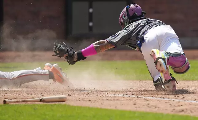 New York Mets catcher Francisco Alvarez, right, can't make the tag at home plate on San Francisco Giants' Casey Schmitt during the fourth inning of a baseball game, Sunday, Aug. 3, 2025, in New York. (AP Photo/Seth Wenig)
