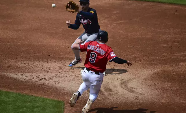 Atlanta Braves shortstop Nick Allen, top, forces out Cleveland Guardians' Kyle Manzardo (9) at second base during the second inning of a baseball game, Sunday, Aug. 17, 2025, in Cleveland. (AP Photo/David Dermer)