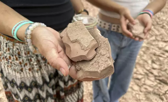 Sisters Zoe Hughes and Phoebe Hughes hold pieces of clay collected from the dry Rio Grande in Albuquerque, N.M., on Thursday, Aug. 21, 2025. (AP Photo/Susan Montoya Bryan)