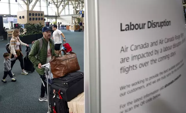 A man tries to check in to his Air Canada flight at the Vancouver International Airport in Richmond, B.C., Canada, on Saturday, Aug. 16, 2025. (Ethan Cairns/The Canadian Press via AP)