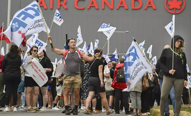 People protest outside Air Canada headquarters in Montreal, Sunday, Aug. 17, 2025, after the federal government is intervened in the labour dispute between the airline and the union representing its flight attendants, ordering binding arbitration and operations to resume. (Graham Hughes/The Canadian Press via AP)