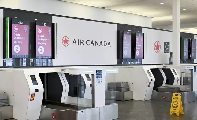 An empty Air Canada bag drop area is shown as Air Canada flight attendants strike at Montreal–Trudeau International Airport in Montreal, Saturday, Aug. 16, 2025. (Graham Hughes/The Canadian Press via AP)