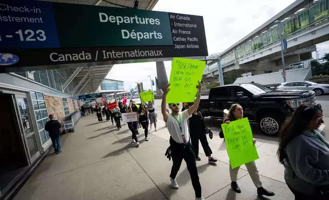 Picketers march around the departures level at the Vancouver International Airport in Richmond, British Columbia, Sunday, Aug. 17, 2025. (Ethan Cairns/The Canadian Press via AP)
