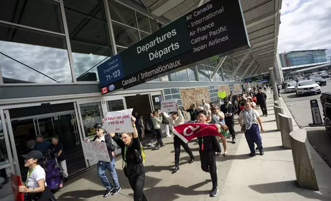 Picketers march around the departures level at the Vancouver International Airport in Richmond, British Columbia, Sunday, Aug. 17, 2025. (Ethan Cairns/The Canadian Press via AP)