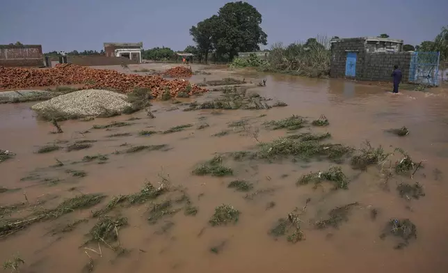 A villager wades through a flooded area after torrential rains on the outskirts of Sodhra town, in Wazirabad district, Pakistan, Thursday, Aug. 28, 2025. (AP Photo/A. Rizvi)