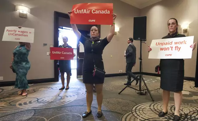 Air Canada executives leave after they are interrupted by Air Canada flight attendants during a press conference as a possible strike looms, in Toronto, on Thursday, Aug. 14, 2025. (Nathan Denette/The Canadian Press via AP)