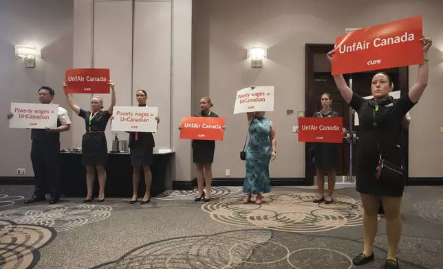 Air Canada flight attendants interrupt Air Canada executives during a press conference as a possible strike looms in Toronto on Thursday, August 14, 2025. (Nathan Denette/The Canadian Press via AP)