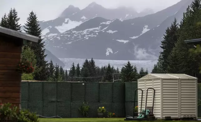 The Mendenhall Glacier is visible in the distance from a residential area, Sunday, Aug. 3, 2025, in Juneau, Alaska. (Marc Lester/Anchorage Daily News via AP)