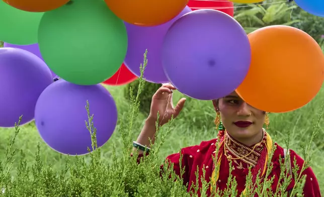 A participant holds balloons during the Pride Parade in Kathmandu, Nepal, Sunday, Aug. 10, 2025. (AP Photo/Niranjan Shrestha)
