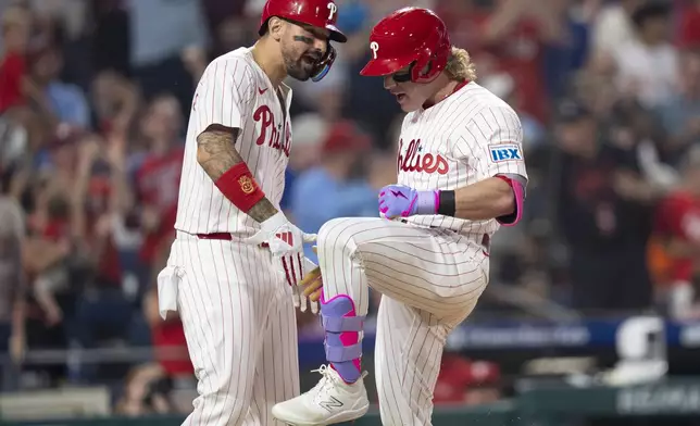 Philadelphia Phillies' Harrison Bader, right, reacts with Nick Castellanos, left, after hitting a three-run home run during the sixth inning of a baseball game against the Baltimore Orioles, Monday, Aug. 4, 2025, in Philadelphia. (AP Photo/Chris Szagola)