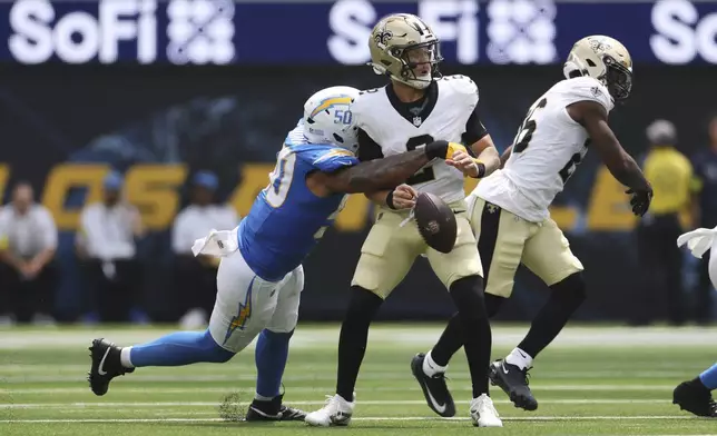 New Orleans Saints quarterback Spencer Rattler (2) fumbles as he is tackled by Los Angeles Chargers linebacker Caleb Murphy (50) during the first half of a preseason NFL football game Sunday, Aug. 10, 2025, in Inglewood, Calif. (AP Photo/Eric Thayer)