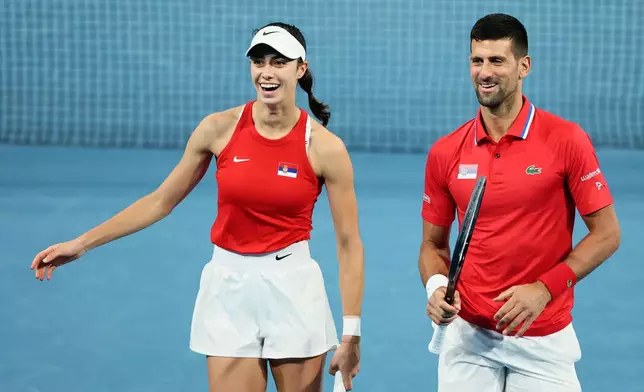 FILE - Novak Djokovic and Olga Danilovic of Serbia laugh on court during their mixed doubles match against Qinwen Zheng and Zhizhen Zhang of China during the United Cup tennis tournament in Perth, Australia, Sunday, Dec. 31, 2023. (AP Photo/Trevor Collens)