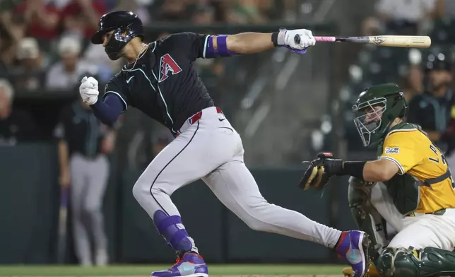 Arizona Diamondbacks' Lourdes Gurriel Jr. hits a single that scores a two runs during the fifth inning of a baseball game against the Athletics, Saturday, Aug. 2, 2025, in West Sacramento, Calif. (AP Photo/Scott Marshall)