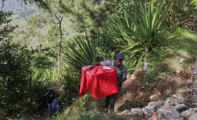 Residents flee their homes to escape the gang violence in the Kenscoff neighborhood of Port-au-Prince, Haiti, Monday, Aug. 4, 2025. (AP Photo/Odelyn Joseph)