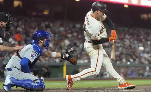 San Francisco Giants' Matt Chapman, right, hits an RBI single in front of Chicago Cubs catcher Carson Kelly during the fifth inning of a baseball game in San Francisco, Wednesday, Aug. 27, 2025. (AP Photo/Jeff Chiu)