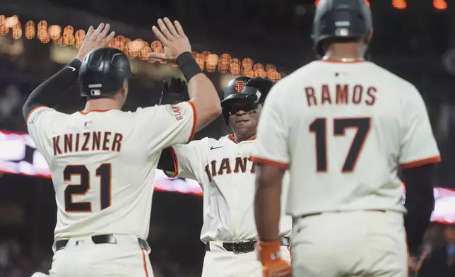 San Francisco Giants' Rafael Devers, middle, celebrates after hitting a three-run home run that also scored Andrew Knizner (21) and Heliot Ramos (17) during the sixth inning of a baseball game against the Chicago Cubs in San Francisco, Wednesday, Aug. 27, 2025. (AP Photo/Jeff Chiu)