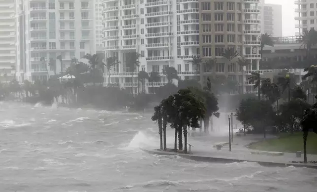 FILE- Waves crash over a seawall at the mouth of the Miami River from Biscayne Bay, Fla., as storm surge from Hurricane Irma impacts Miami on Sept. 10, 2017. (AP Photo/Wilfredo Lee,File)
