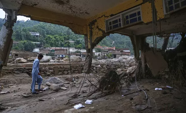 A local resident looks a damaged home following Friday's flash flooding at a neighborhood of Pir Baba, an area of Buner district, in Pakistan's northwest, Sunday, Aug. 17, 2025. (AP Photo/Muhammad Sajjad)