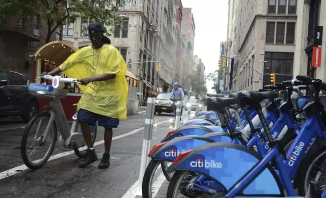 Reggie collects bikes in the rain for Citi Bike to load into a company van on 20th Street and Park Avenue South, Thursday, July 31, 2025, in New York. (AP Photo/Pamela Hassell)