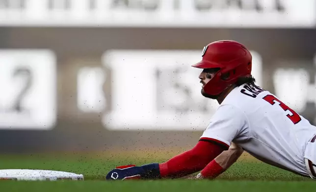 Washington Nationals' Dylan Crews slides into second base for a steal during the first inning of a baseball game against the Philadelphia Phillies, Thursday, Aug. 14, 2025, in Washington. (AP Photo/Terrance Williams)