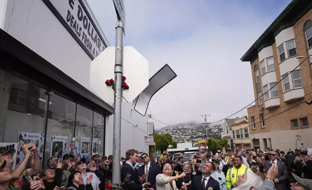 Mayor Daniel Lurie, center right, watches as supervisor Chyanne Chen, left of Lurie, and Trixie Garcia, second from bottom right, unveil the naming of Jerry Garcia Street, Friday, Aug. 1, 2025, in San Francisco. (AP Photo/Godofredo A. Vásquez)