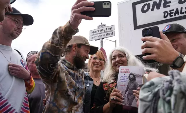 Trixie Garcia, second from right, poses for selfies with a Grateful Dead fans, following the unveiling of Jerry Garcia Street in San Francisco, Friday, Aug. 1, 2025. (AP Photo/Godofredo A. Vásquez)