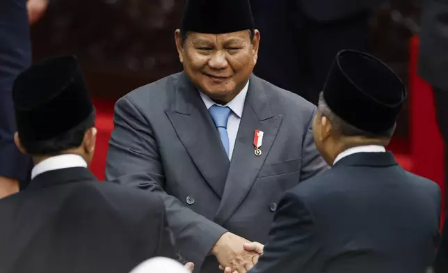 Indonesian President Prabowo Subianto shakes hands with a member of the parliament after delivering his annual State of the Nation Address ahead of the country's Independence Day, in Jakarta, Indonesia, Monday, Aug. 15, 2025. (Bay Ismoyo/Pool Photo via AP)