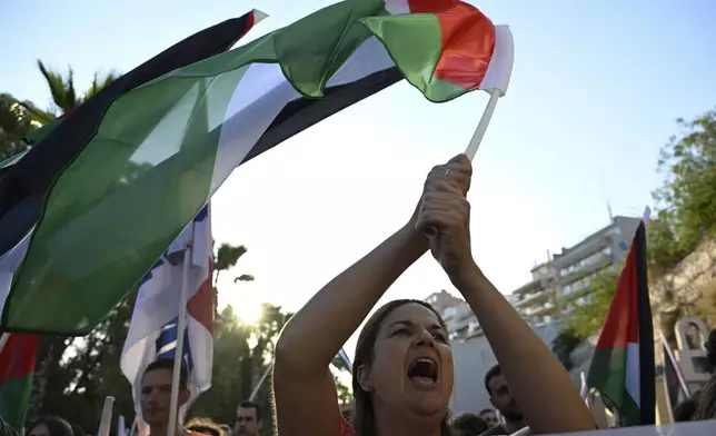 A protester shouts slogans as she waves a Palestinian flag, during a rally to protest the arrival of a cruise ship with Israelis, in Piraeus port, Greece, Thursday, Aug. 14, 2025. (AP Photo/Michael Varaklas)