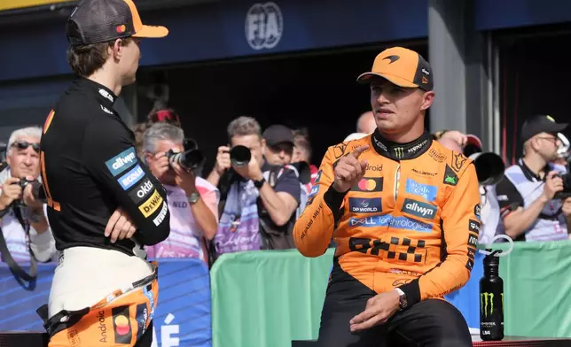 McLaren driver Lando Norris of Britain, right, talks to McLaren driver Oscar Piastri of Australia after the qualifying session ahead of the Formula One Dutch Grand Prix at the Zandvoort racetrack in Zandvoort, Netherlands, Saturday, Aug. 30, 2025. (AP Photo/Patrick Post)
