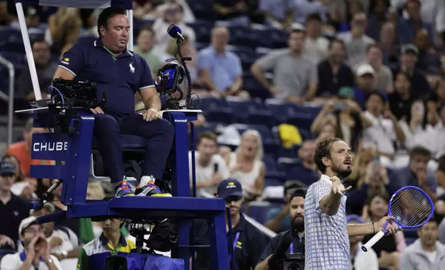 Daniil Medvedev, of Russia, bottom right, reacts next to chair umpire, Greg Allensworth, left, after a photographer ran onto the court during a match against Benjamin Bonzi, of France, in the first-round of the U.S. Open tennis championships, Sunday, Aug. 24, 2025, in New York. (AP Photo/Adam Hunger)