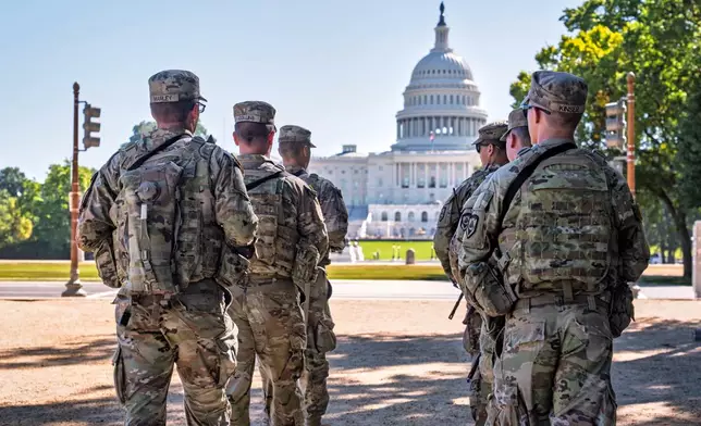 Armed National Guard soldiers from West Virginia patrol the Mall near the Capitol in Washington, as part of President Donald Trump's order to impose federal law enforcement in the District of Columbia, Tuesday, Aug. 26, 2025. (AP Photo/J. Scott Applewhite)