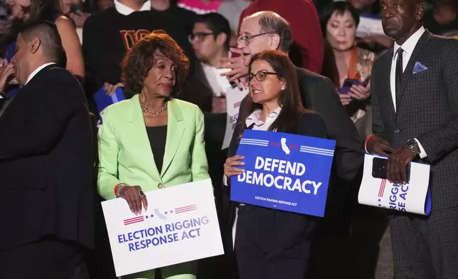 U.S. Rep. Maxine Waters, D-Calif., left, waits with others for the start of a news conference with California Gov. Gavin Newsom Thursday, Aug. 14, 2025, in Los Angeles. (AP Photo/Marcio Jose Sanchez)