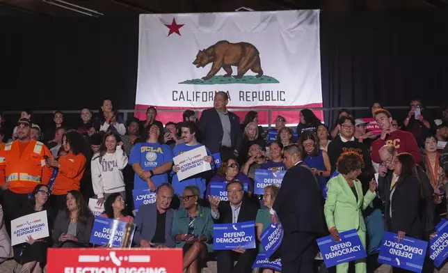 Politicians and community members await a news conference with California Gov. Gavin Newsom Thursday, Aug. 14, 2025, in Los Angeles. (AP Photo/Marcio Jose Sanchez)