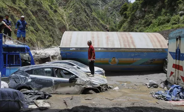FILE - Damaged vehicles are visible after severe monsoon rains flooded the Bhotekoshi River and swept away a key bridge connecting the country with China in Rasuwagadi, north of the capital, Kathmandu, Nepal, July, 9, 2025. (AP Photo/Sujan Gurung, File)