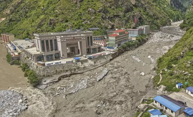 FILE - Chinese land on left, and Nepalese land on right are visible after Friendship Bridge, a key bridge over the Bhotekoshi River connecting Nepal with China was swept away in monsoon rain in Rasuwagadi, north of the capital, Kathmandu, Nepal, Wednesday, July, 9, 2025. (AP Photo/Sujan Gurung, File)