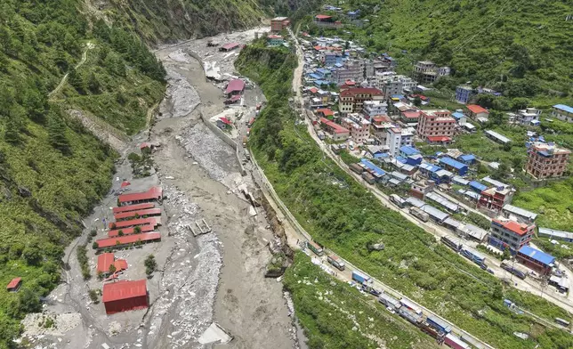 FILE - Damaged buildings, on left, are visible after severe monsoon rains flooded Bhotekoshi River and swept away a key bridge connecting the country with China in Rasuwagadi, north of the capital, Kathmandu, Nepal, July, 9, 2025. (AP Photo/Sujan Gurung, File)