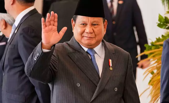Indonesian President Prabowo Subianto waves to journalists at Merdeka Palace in Jakarta, Indonesia, Tuesday, July 29, 2025. (AP Photo/Achmad Ibrahim)
