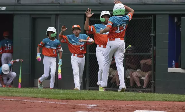 Venezuela's Abraham Rodriguez celebrates after being brought home on a walk against Puerto Rico, during the second inning of a baseball game at the Little League World Series, Wednesday, Aug. 13, 2025, in South Williamsport, Pa. (AP Photo/Caleb Craig)