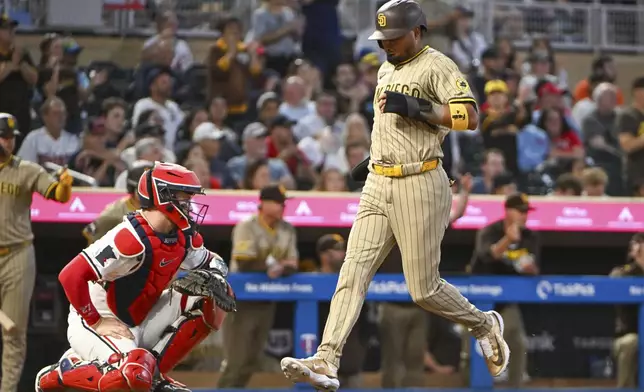 San Diego Padres' Luis Arraez, right, scores as he runs past Minnesota Twins catcher Ryan Jeffers, left, on an RBI single by Ryan O'Hearn during the seventh inning of a baseball game Saturday, Aug. 30, 2025, in Minneapolis. (AP Photo/Craig Lassig)